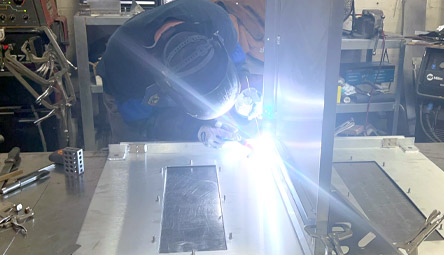 New Com welding technician assembling a NEMA rated enclosure